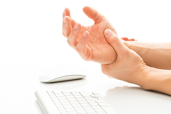 Linke Hand hält rechtes Handgelenk, Tastatur und Maus