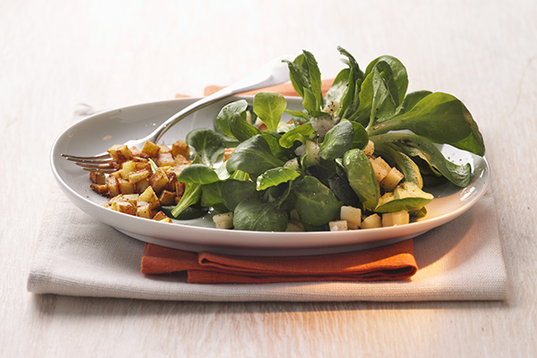 Feldsalat mit Croûtons auf weißem Teller